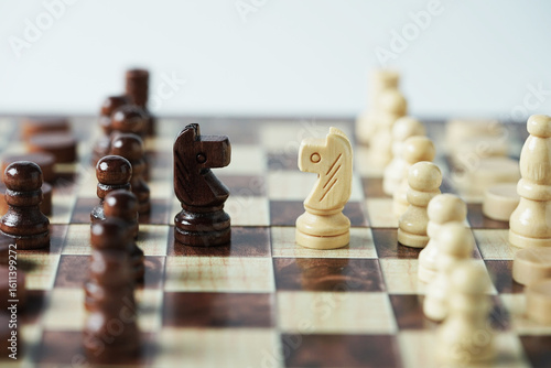 The confrontation between chess brown horse and white horse. Chess pieces in chess board games for business, challenge, leadership, strategy and success.