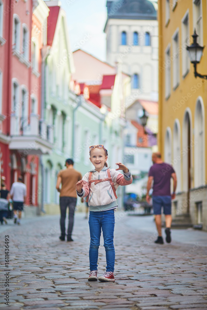 Naklejka premium Adorable preschooler girl having fun on a street of Tallinn, Estonia.
