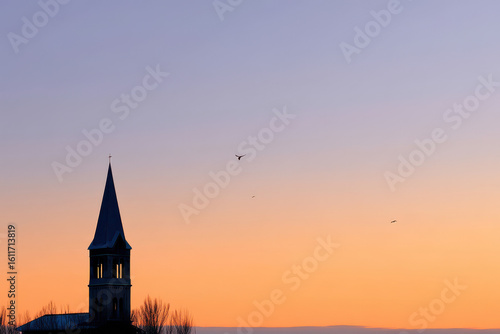 delicate church bell silhouette stands gracefully against evening sky illuminated by fading light