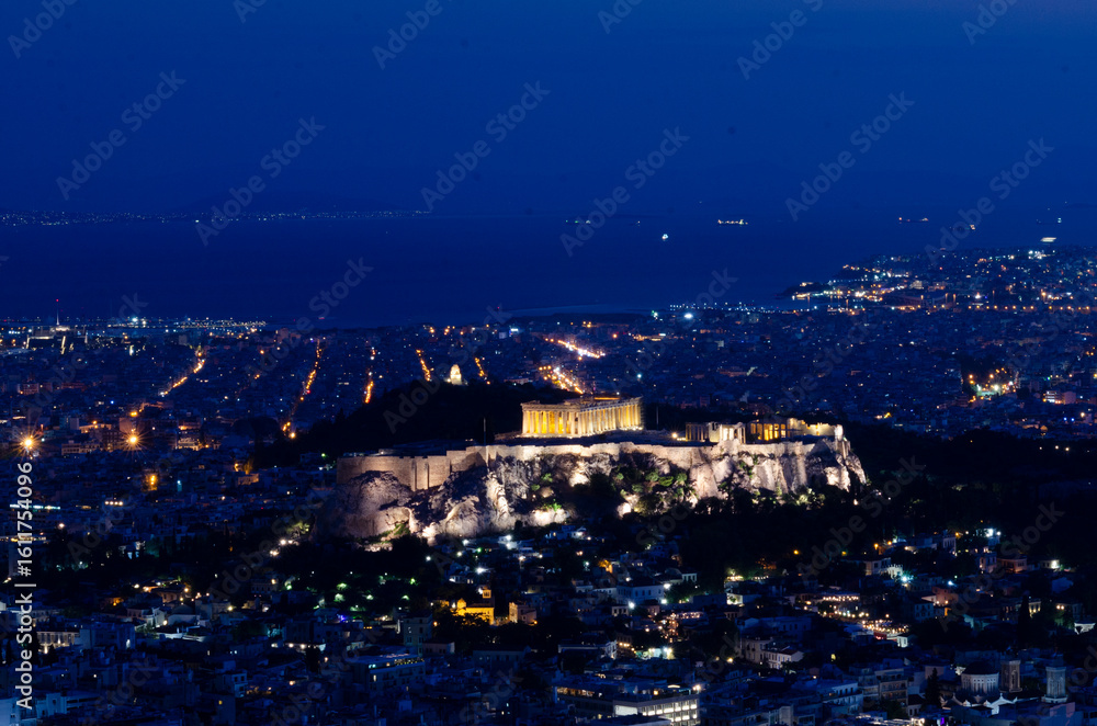 Fototapeta premium Evening view of The Parthenon and Acropolis in Athens Greece at 'Blue Hour' from Lycabettus Hill in downtown Athens Greece