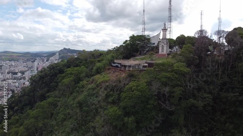 MIRANTE DO MORRO DO CRISTO, JUIZ DE FORA, MINAS GERAIS, BRAZIL - DECEMBER 20, 2021: Drone view of the highest lookout in the city. Panorama showing the hilltop with antennas and the city below.