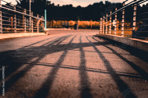 Wooden bridge casting long shadows at sunset