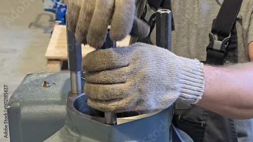 Mechanic placing metal rods into engine block cylinders
