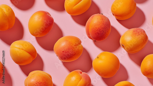 Vibrant and appetizing scene with sweet apricots placed on a pink background, creating a cheerful and colorful contrast.

