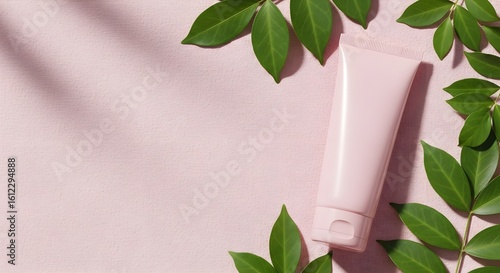 Pink Cosmetic Tube with Green Leaves on Fabric Background – Minimalist Beauty Composition