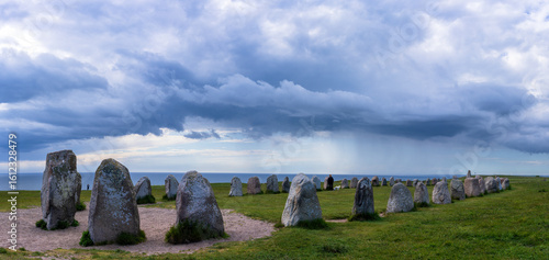 Ale's Stones, in Swedish Ales stenar, a megalithic monument in Scania in southern Sweden. It is a stone ship, Viking burial site. A storm is approaching in the background.