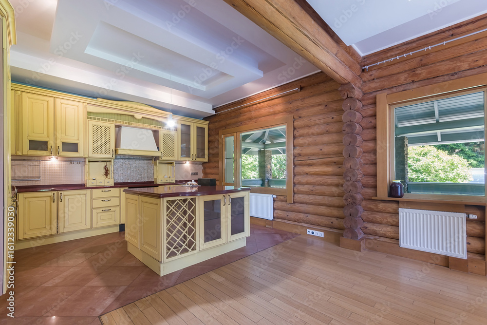 Fototapeta premium Elegant kitchen in a log cabin with modern design. Large windows provide natural light and a view of the lush greenery outside.