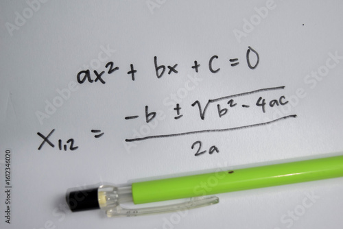 Concept of general quadratic equation write on book isolated on Wooden Table.