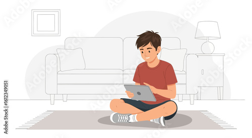 Boy Sits Cross Legged On The Floor Holding Digital Tablet At Home