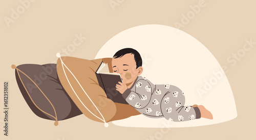 Adorable little baby reading a book while lying on pillows in cozy setting