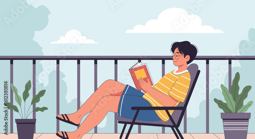 Young Man Reads a Book On Balcony During A Sunny Day Relaxing
