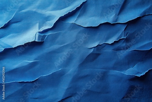 Wallpaper Mural Close-up of layered and torn blue paper creating textured ridges and shadows with varying shades of blue Torontodigital.ca