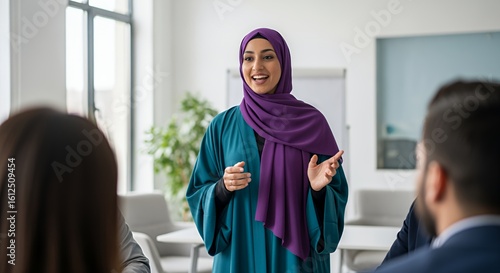 A confident woman in a hijab confidently leads a business meeting, sharing her ideas and insights with her colleagues.