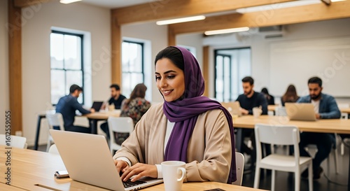 Wallpaper Mural A young woman in a hijab works diligently on her laptop in a modern, bright coworking space, surrounded by other professionals. Torontodigital.ca