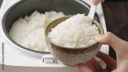 cooked rice filling a bowl from rice cooker
