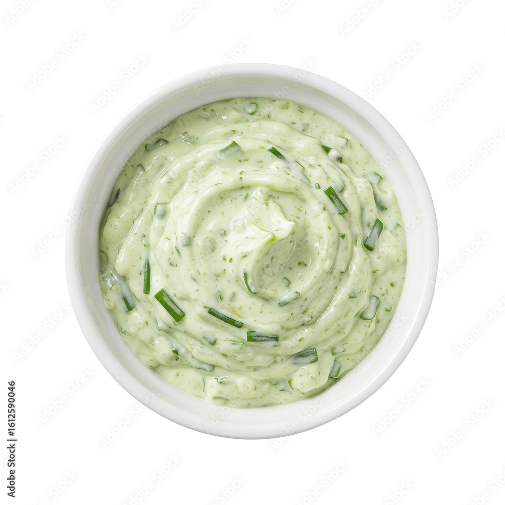 Obraz premium Creamy green herb sauce in a white bowl, ready for serving with fresh vegetables or dishes