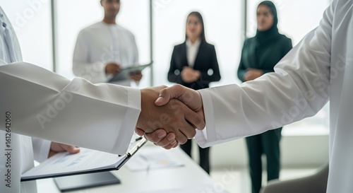 A successful business deal is sealed with a handshake between two people in formal attire, signifying partnership and collaboration.