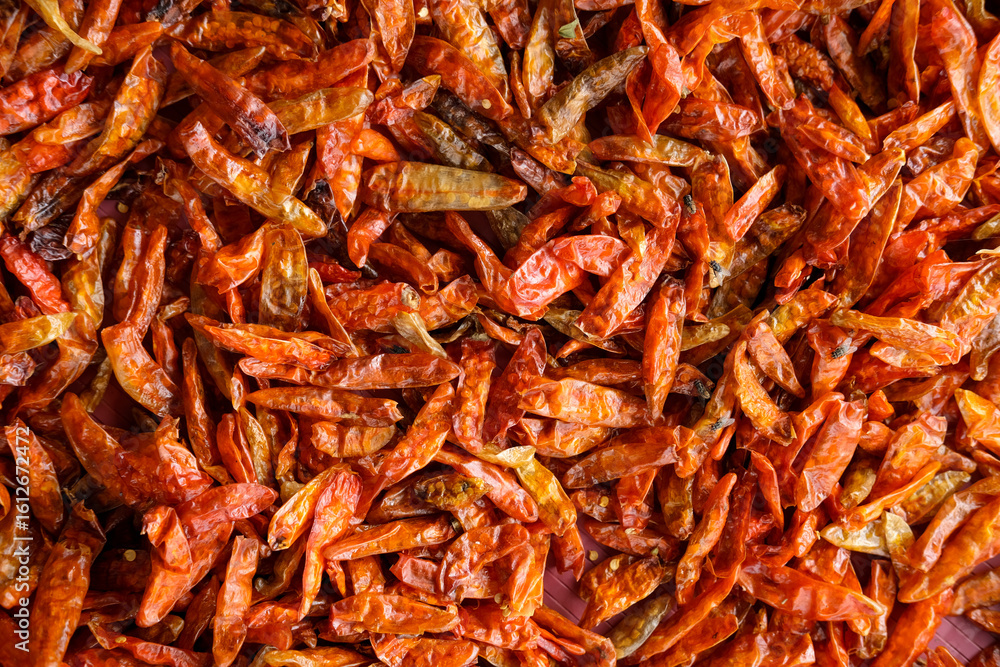 Obraz premium Freshly harvested chilies are sun-dried using traditional methods, then processed into products like chili powder, instant sambal, and chili extract to increase market value and farmers’ income.