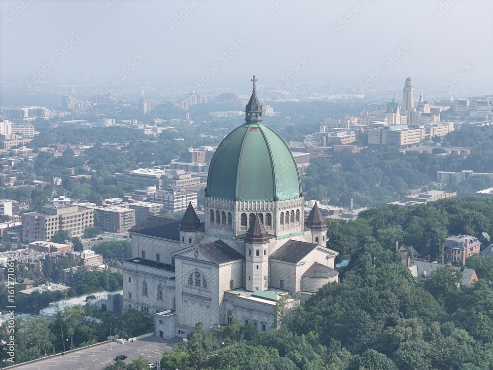 Fototapeta premium Aerial view of Saint Joseph's Oratory in Montreal under heavy smog, haze and forested hills. c.