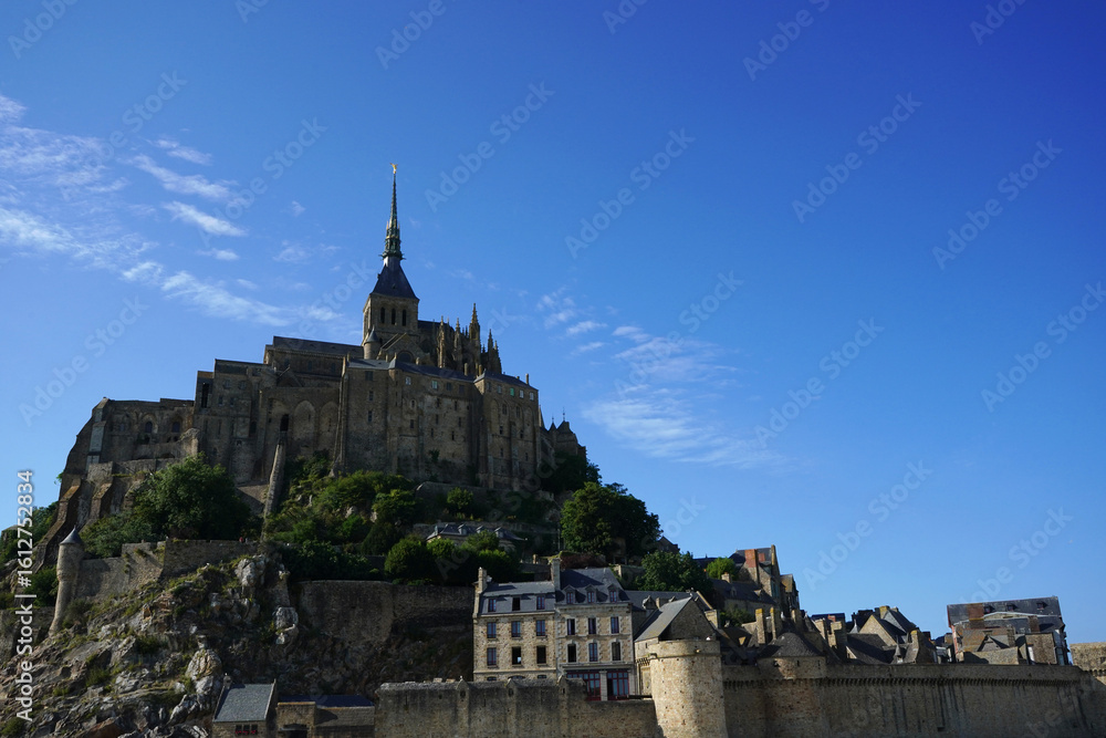 Obraz premium Mont Saint-Michel under a Vibrant Blue Sky, Normandy, France