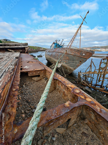 old abandoned sunken ship in the water at the ship cemetery wood pattern