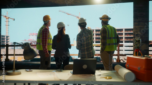 Bilde på lerret Construction workers and architect reviewing building plans on site