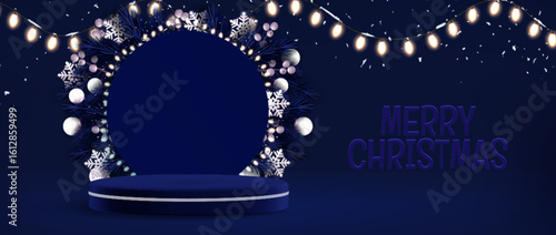Blue Christmas podium decorated with circular wreath of pine branches, snowflakes, silver ornaments and glowing string lights. Navy platform display with warm bulb garland for festive product showcase