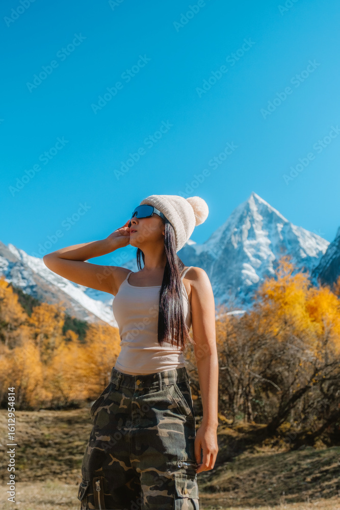 Naklejka premium Bipenggou national park Young asian tourist with the Beautiful snow mountains in autumn, Chengdu ,Sichuan in China.