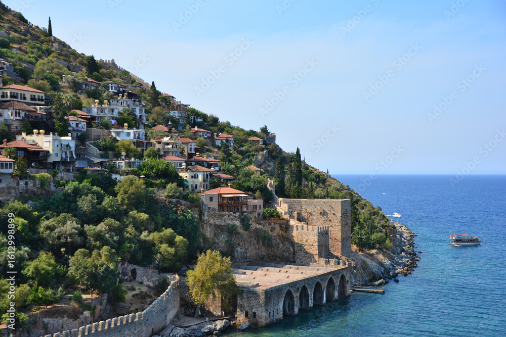 Naklejka premium Coastal Fortress and Cliffside Village Under a Clear Sky copy space