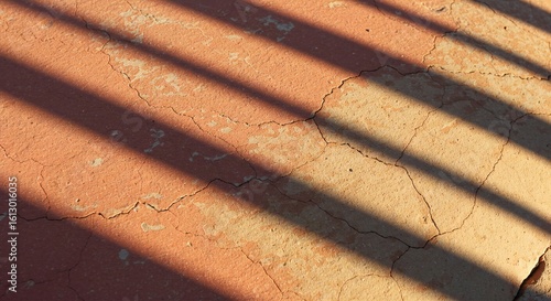 Cracked Red Earth Texture with Sunlight and Shadow Stripes Abstract