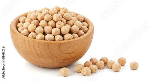 Wooden bowl filled with dried chickpeas scattered on white