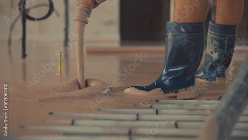 Canvas-taulu Construction worker pouring self-leveling anhydrite gypsum screed on floor
