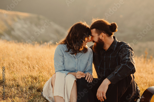 A loving couple enjoys a tender moment together in a beautifully sunlit field, embodying true love and deep connection