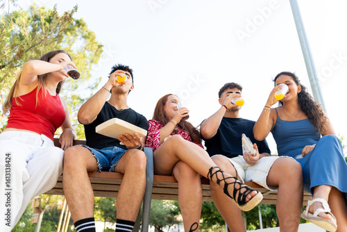 Valokuva Group of young adults enjoying drinks and socializing outdoors