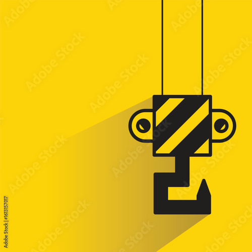 industrial hoist and crane hook with shadow yellow background