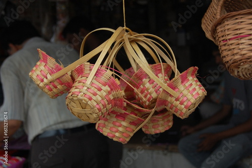 Colorful Christmas decorations and ornaments, including a green tree and candy, are arranged on a rustic wooden table