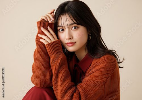 深まる秋のファッション、赤茶色のニットセーターとダークレッドのブラウスを着た女性ファッションモデル