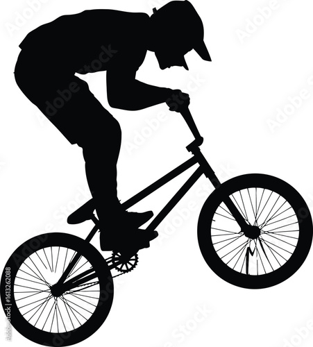 Athletic bmx rider performing a trick on a bicycle in a dynamic silhouette