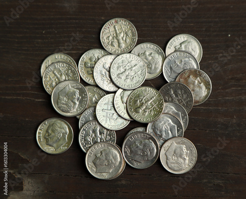 A big pile of american dime coins on wooden table
