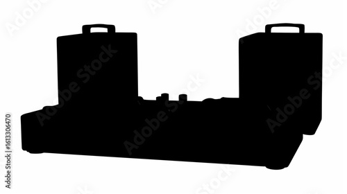 Silhouette of a dual speaker system with a mixing console featuring knobs and switches in a dark setting