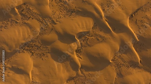 Top-down sunrise aerial view of textured orange sand dunes with long shadows in Corralejo Desert, Fuerteventura