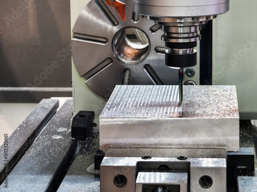 Precision milling process on metal block in modern workshop during daylight hours in a clean industrial environment