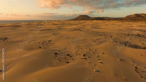 Pre-dawn aerial view of Corralejo desert with distant ocean and volcanic mountains, Fuerteventura