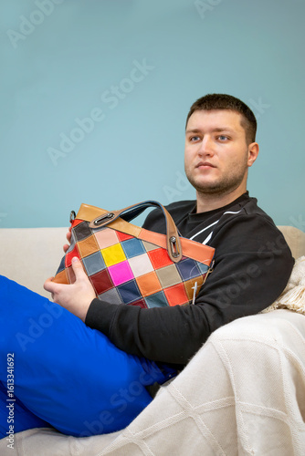 Man in blue pants with a woman's bag