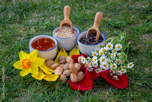Colorful Display of Natural Foods and Blossoms on a Grassy Background