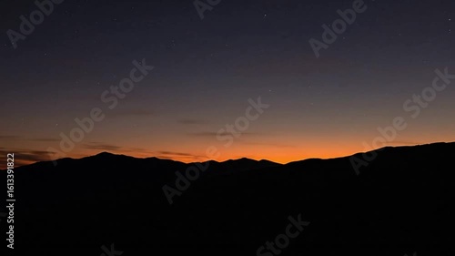 Wallpaper Mural Dark mountain silhouettes beneath a vibrant orange and purple sunset sky Torontodigital.ca