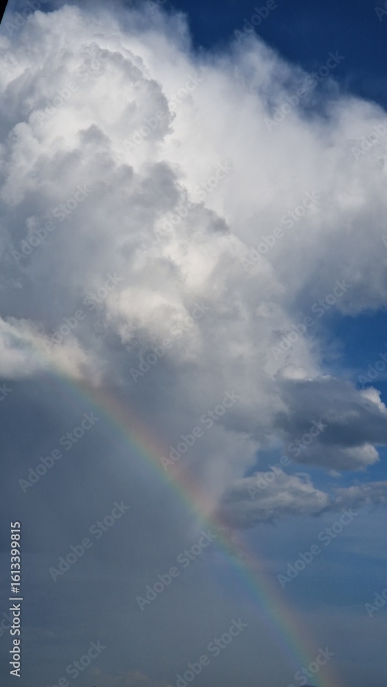 Brilliant rainbow stretches across a dramatic sky after summer rain Brilliant rainbow stretches across a dramatic sky after summer rain