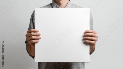 Person holds blank white square sign