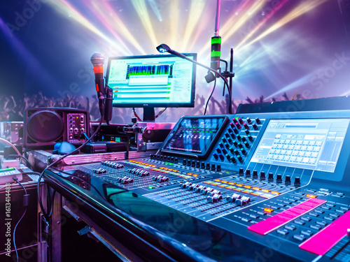 Fotografi Audio mixing console and microphones at live concert event with crowd and stage lighting in the background