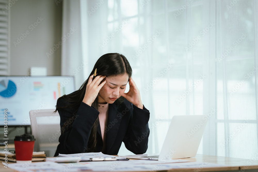 A tired businesswoman sits at her desk, visibly stressed and overworked, struggling with burnout, pressure, and mental fatigue in a demanding corporate environment filled with financial concerns. A tired businesswoman sits at her desk, visibly stressed and overworked, struggling with burnout, pressure, and mental fatigue in a demanding corporate environment filled with financial concerns.